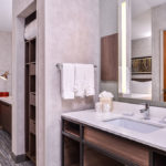 Hotel bathroom with sink and mirror and closet